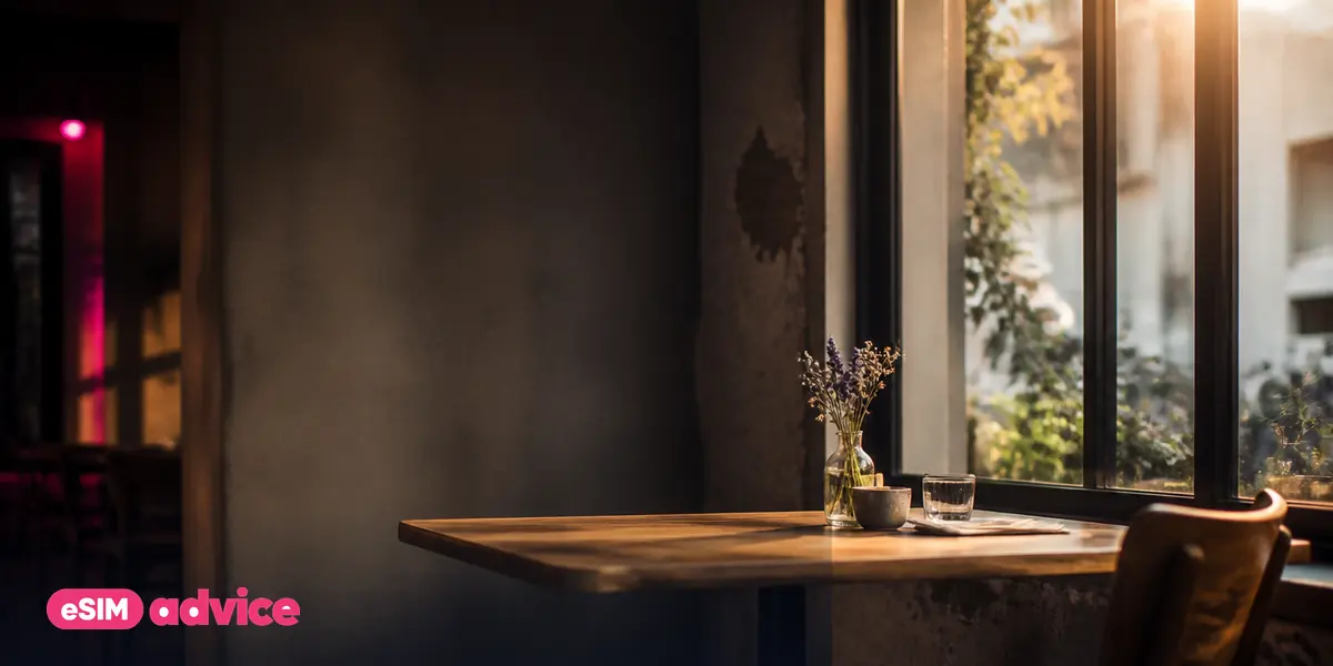 A sunlit café interior with a single empty table by the window