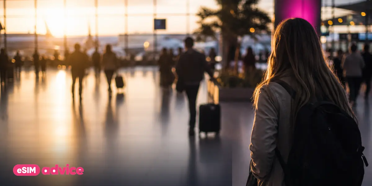 An airport departures hall at golden hour with travellers in motion blur