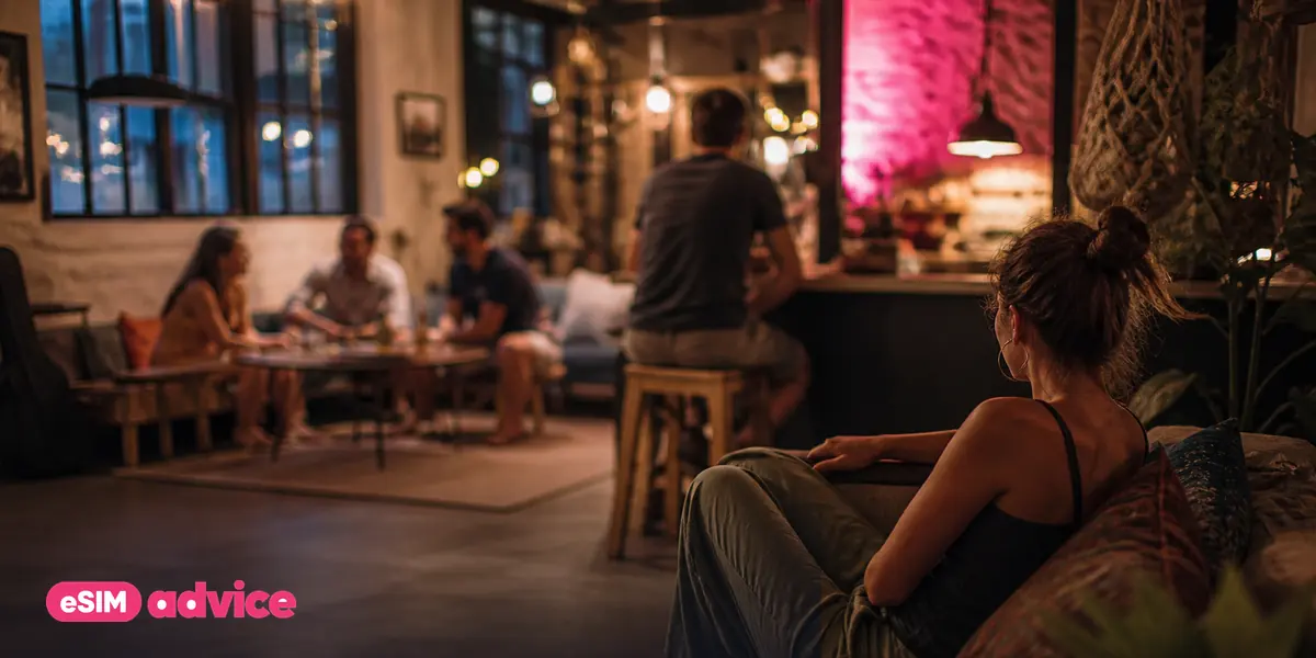 A hostel common area in the evening with people relaxed and out of focus
